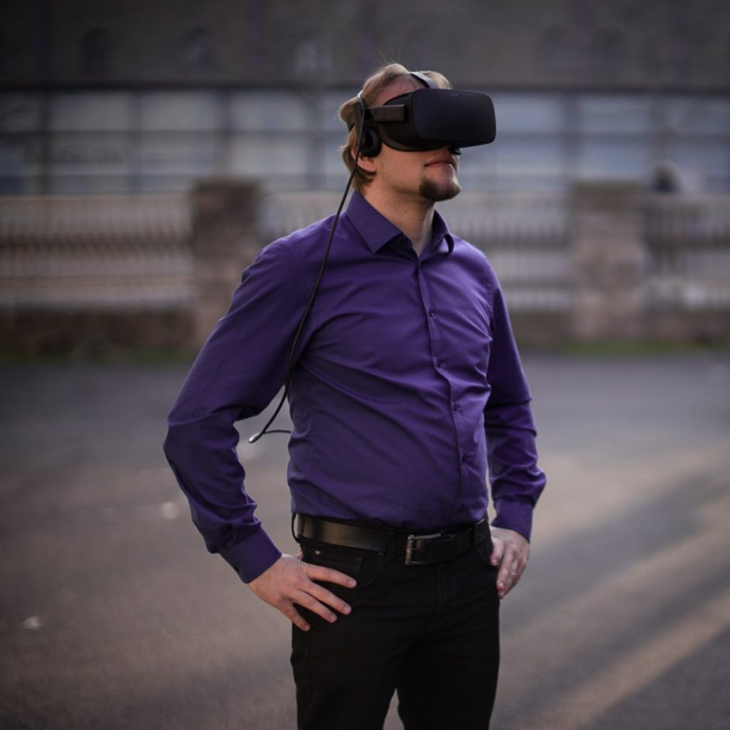 Mann steht mit AR-VR-Brille in einer industriellen Umgebung